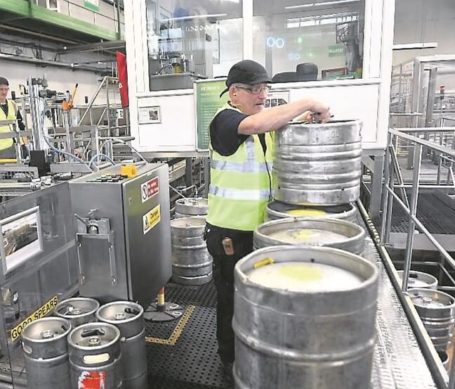 Donie Hosford, cuya familia ha trabajado en la cervecería desde 1856 trabajando en cambiar las esferas de los barriles en Heineken Irlanda, Cork. Cuadro Dan Linehan